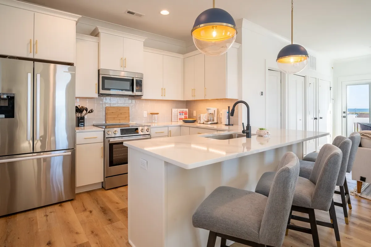A modern kitchen with an island countertop, Bosch appliances, and bar stools for counter seating. The space is stylish yet functional, ideal for socializing while preparing meals.