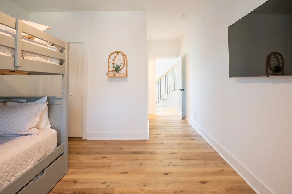 A cozy family suite with full-over-full bunk beds, a decorative shelf with a plant, and a television. The space encourages storytelling, movie nights, and shared moments—ideal for children or teens.